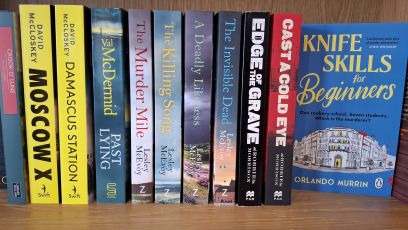 A row of crime novels on a shelf