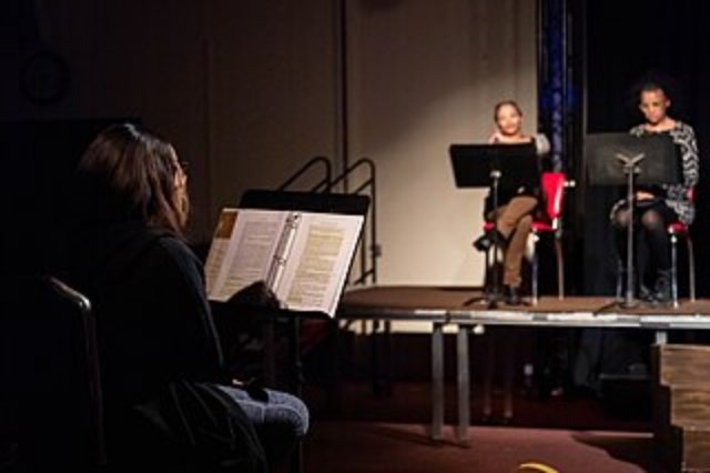Some people reading a play in a theatre