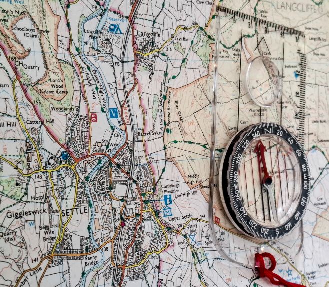Part of an Ordnance Survey map of Settle with a compass.