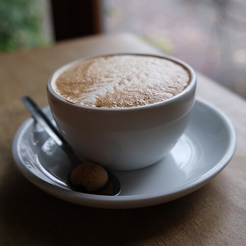 A cup of coffee with milk in.